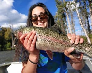 Guest holding a large rainbow trout while fly fishing on Lake Creek in Alaska