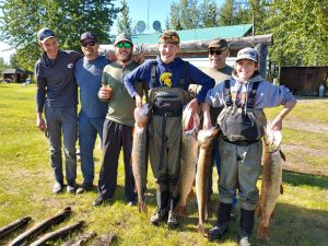 Guests holding large northern pike caught near Lake Creek Lodge in Alaska