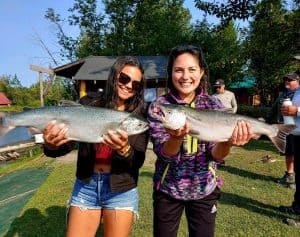 Two anglers holding chrome coho on Lake Creek in southwest Alaska
